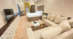 a living room with a couch and a bed at سيبار للشقق المخدومة Sippar Serviced Apartments in Hotat bani tamim