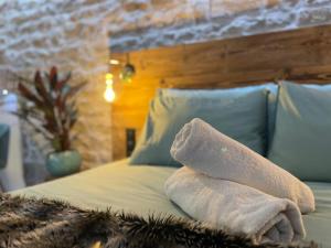 - un lit avec des serviettes assises au-dessus dans l'établissement Les Jardins Secrets - Gare & Centre by Apparts Spa Dijon, à Dijon