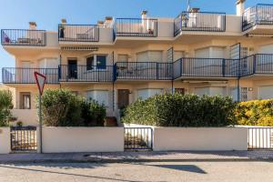 un edificio con balcones y arbustos delante de él en Grifeu 17 Apartamento al lado de la playa en Llançà