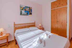 1 dormitorio con 2 camas blancas y puerta de madera en Grifeu 17 Apartamento al lado de la playa en Llançà