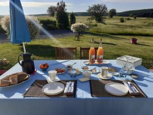 a blue table with plates and bottles of wine at B&B Au fil des saisons sur la Wiels in Fauvillers