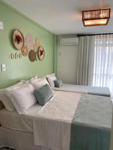 een slaapkamer met twee bedden met hoeden aan de muur bij Gran Lençóis Flat Residence Mandacaru 311 - 611 in Barreirinhas