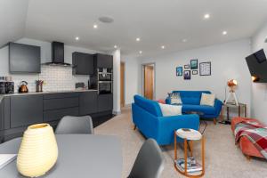 a living room with a blue couch and a kitchen at Air Host and Stay - The Scouse House - Quirky 2 bedroom mews house mins from Sefton Park in Liverpool