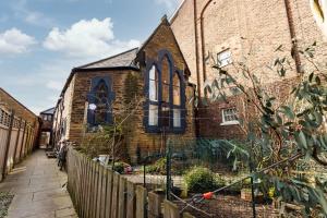 利物浦的住宿－Air Host and Stay - The Scouse House - Quirky 2 bedroom mews house mins from Sefton Park，前面有栅栏的砖房