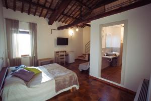 een slaapkamer met een groot bed en een badkamer bij La Residenza dei Priori in Tarquinia