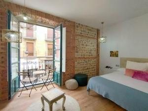 a bedroom with a bed and a table and a balcony at Hostal Albany Ancha in León