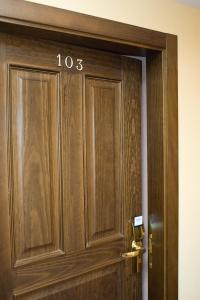 a wooden door with the number on it at Hotel Rural "Victoria" in Humanes