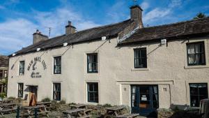 a white building with picnic tables in front of it at The Blue Bell Inn in Kettlewell