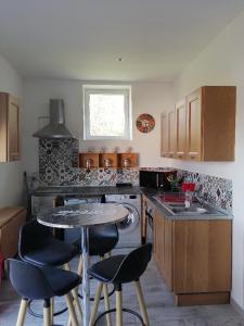 a kitchen with a table and some chairs in it at lou pitchou prats in Audon