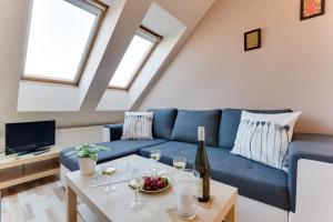 sala de estar con sofá azul y mesa con copas de vino en Jane's Charming Apartment en Praga
