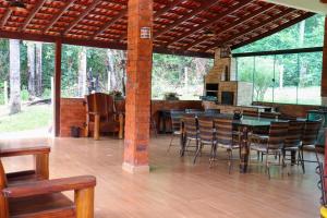 een afgeschermde veranda met een tafel en stoelen bij CHACARA ESPERANÇA in Pirenópolis