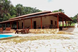 een huis met een paviljoen met een tafel en een zwembad bij CHACARA ESPERANÇA in Pirenópolis +30 foto's