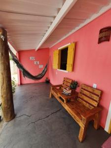 a room with a bench and a hammock in a house at pôr do sol - chalés in São Miguel do Gostoso