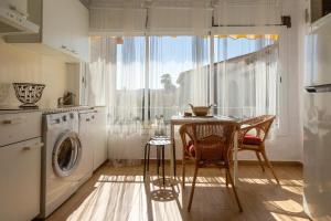 een keuken met een tafel en een wasmachine bij Apartamento Retiro Sol in Denia