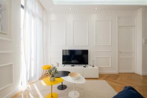 a living room with a tv and a table at 3-bedroom apartment in the heart of Cannes in Cannes
