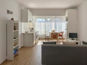 een woonkamer met een bank en een keuken met een tafel bij Apartamento Retiro Sol in Denia