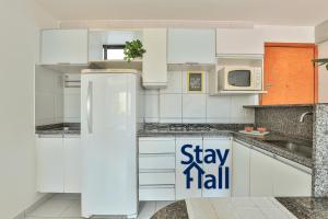 Una cocina blanca con un refrigerador y un cartel que dice "mantente alto". en Piso Equipado-Jaqueira Excelente Ubicación-SH032, en Recife