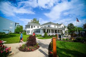 a man walking in front of a white house at The Lakehouse Inn Geneva in Geneva-on-the-Lake