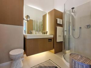 ein Bad mit einem Waschbecken und einer Dusche in der Unterkunft Luxury Omuntu-Design-Apartment Deluxe in München