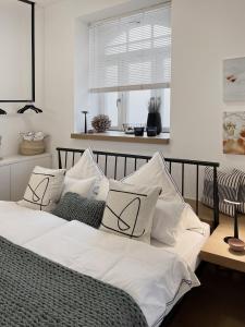 Luxury Omuntu-Design-Apartment Deluxe في ميونخ: غرفة نوم بسرير ذو شراشف ووسائد بيضاء