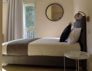 a bedroom with a bed with a mirror and a table at B12 Inn in Jerusalem