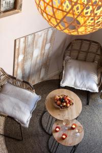 a room with two chairs and a table with a bowl of fruit at Vila De La Mar & Spa in Saintes-Maries-de-la-Mer