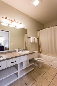 a bathroom with a sink and a toilet and a mirror at Bay Colony Unit 771 - Upper Level in Nisswa