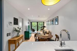 a kitchen and living room with a sink and a table at Urban City Escape with pool, gym, sauna and spa in Auckland