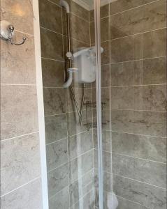a shower with a glass door in a bathroom at Whiskey river chalet-Glan Gwna Holiday Park in Caernarfon