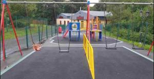 a playground with a yellow umbrella in the middle at Whiskey river chalet-Glan Gwna Holiday Park in Caernarfon