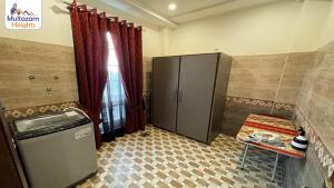 a small room with a refrigerator and a table at Multazam Heights, DHA Phase 8 - 3 Bedrooms Luxury Apartments in Lahore
