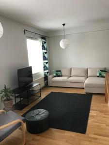 a living room with a white couch and a black rug at City center apartment with sauna, Rovakatu 13 in Rovaniemi