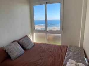 Un dormitorio con una cama y una ventana grande. en Apartamento 24th floor & sea view, en Alicante