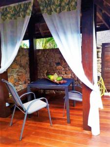 einen Tisch mit einer Obstschale und 2 Stühlen in der Unterkunft MOOREA - Villa Mouaroa Legends in Papetoai