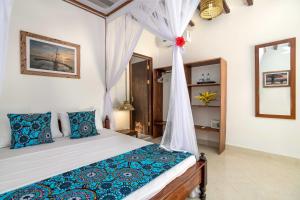 a bedroom with a bed with a canopy at Poa Poa Bungalows in Kiwengwa