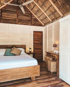 um quarto com uma cama e um tecto de madeira em Monoloko Lodge Popoyo em El Limón