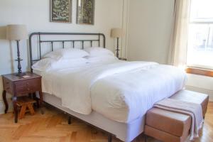 a bedroom with a large bed with white sheets and a table at Pert House in Potsdam