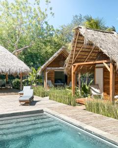a resort with a swimming pool and a house at Monoloko Lodge Popoyo in El Limón