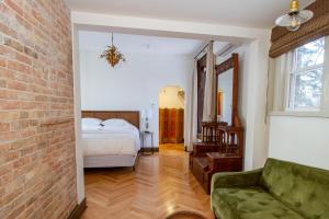 um quarto com uma cama, um sofá e uma parede de tijolos em Pert House em Potsdam