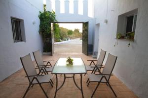 a table and chairs in a courtyard with a doorway at Vivienda Rural Cortijo de Liche in Arcos de la Frontera