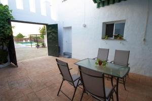 a patio with a glass table and chairs and a courtyard at Vivienda Rural Cortijo de Liche in Arcos de la Frontera