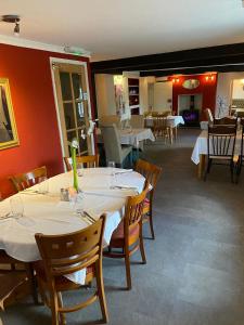 un restaurant avec tables et chaises et nappes blanches dans l'établissement Prestleigh inn, à Shepton Mallet