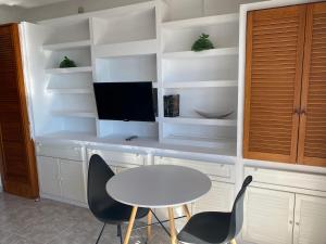 ein Zimmer mit einem Tisch und zwei Stühlen und einem Fernseher in der Unterkunft Apartamento 19th floor & sea view in Alicante