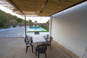 a patio with a table and chairs and a pool at Vivienda Rural Cortijo de Liche in Arcos de la Frontera