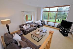 a living room with couches and a flat screen tv at Stunning Country House with beautiful views in Inverurie