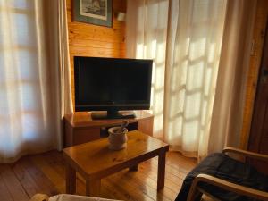 a living room with a television and a coffee table at La Cabaña de Heidi in Concordia