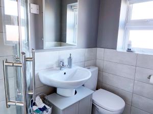 a white bathroom with a sink and a toilet at Gracehill Lodge - Guest Accommodation in Stranocum +10 photos