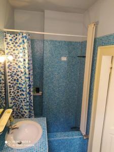 y baño azul con lavabo y ducha. en Exclusive Ca Quadri Apartments, en Venecia