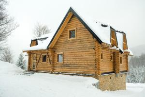 una cabaña de madera en la nieve en Drvena Kuca RUŽA en Kopaonik