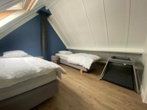 - une chambre mansardée avec 2 lits et une fenêtre dans l'établissement vakantiehuis nieuwendamme, à Nieuport